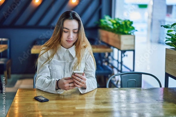 Fototapeta young woman in a shopping center in cafe waiting for an order