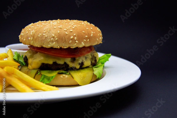 Fototapeta Burger with beef cutlet, tomato sauce and french fries on black background