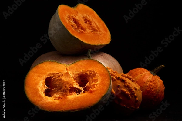 Fototapeta Composition of cut half pumpkins on a black background