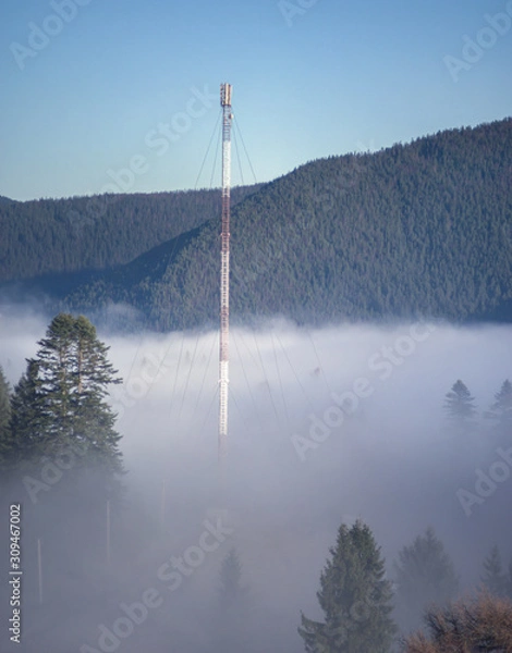 Fototapeta Cell tower in the fog in the mountains