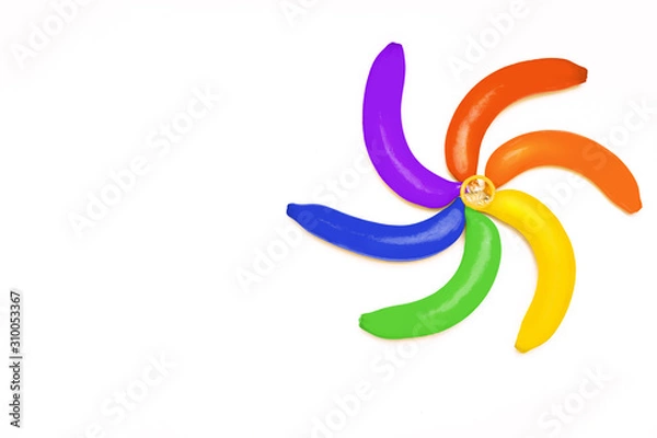 Fototapeta LGBT colored rainbow bananas and condom on white background. The minimum concept of LGBT. Blank space for text. Flat lay. Mock up