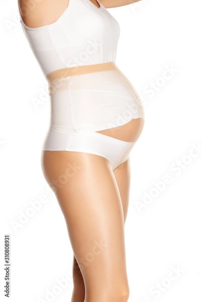 Fototapeta Pregnant woman in nylon tights on white background