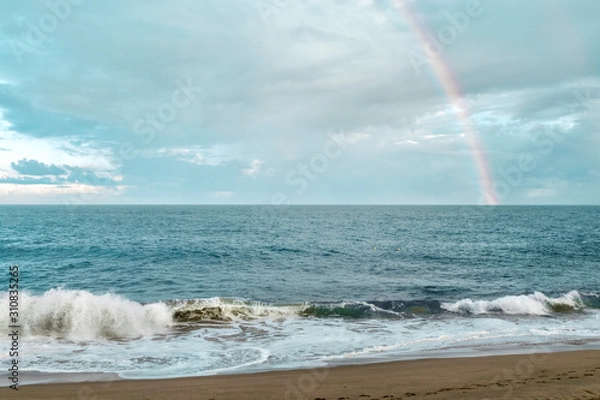 Fototapeta rainbow over the sea. light surf and sandy beach under the rainbow