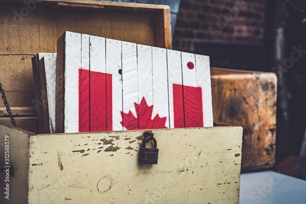 Fototapeta The Canadian flag painted in a piece of wood