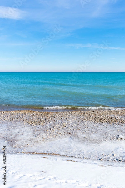 Fototapeta Beautiful turquoise colored water along Lake Michigan shoreline in winter - vertical