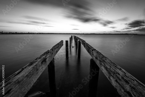 Obraz Black and white wooden jetty leading into the sea 