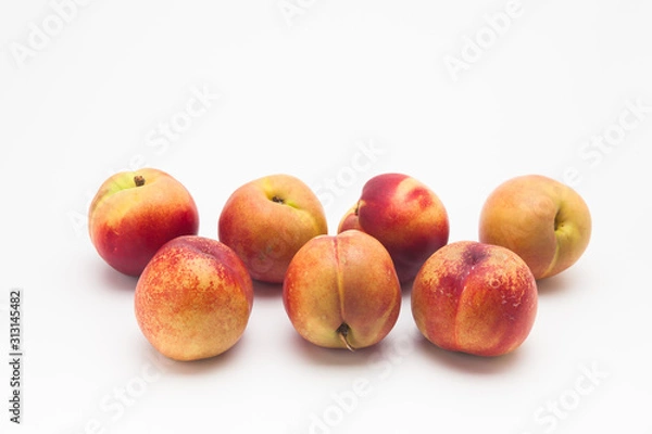 Fototapeta Group of ripe peaches on a white