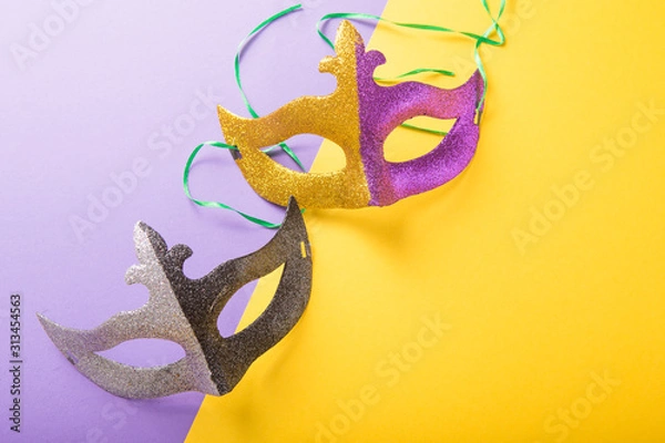 Fototapeta A festive, colorful group of mardi gras or carnivale mask on a purple background. Venetian masks.