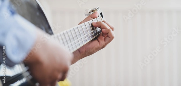 Fototapeta Cropped shot of young man playing acoustic guitar