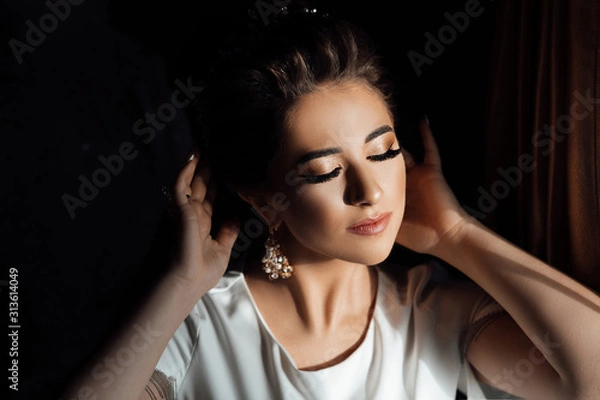 Fototapeta Morning preparations. Wedding. Beautiful bride with makeup and hair style. Bride posing. Bride with her eyes closed shows makeup. Beauty, fashion. Wedding.