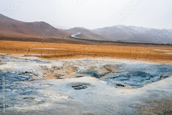 Fototapeta Bubbling geothermal hot/mud pool in the Hverarond area near Myvatn in the Icelandic landscape. Colorful and textured volcanic mineral rich sulphur ground infront.