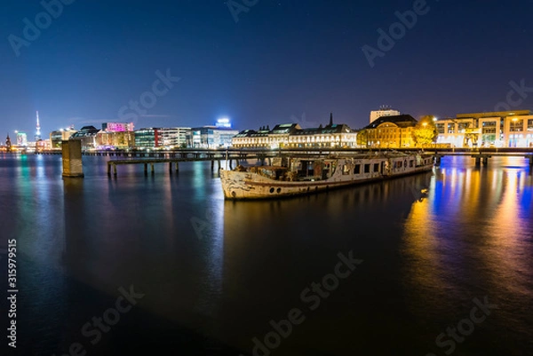 Fototapeta Old big boat that ran aground, an old boat lies on the ground, night shot, colorful, Berlin, Treptow harbor