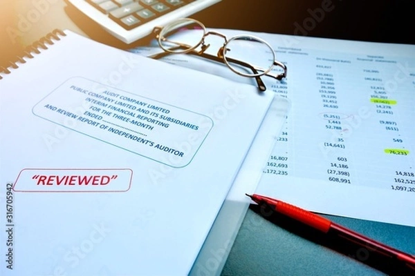 Fototapeta The reviewed financial statement, eyeglass, highlight pencil, calculator, laptop and edited paper. It's important work of the account, finance, internal and external audit must to accurate and timely