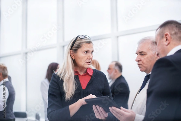 Obraz serious employees discussing business document before meeting.