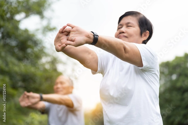 Fototapeta Asian senior people stretching their arms before exercising.