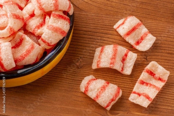 Fototapeta Pelleted salted snack bacon on a wooden background