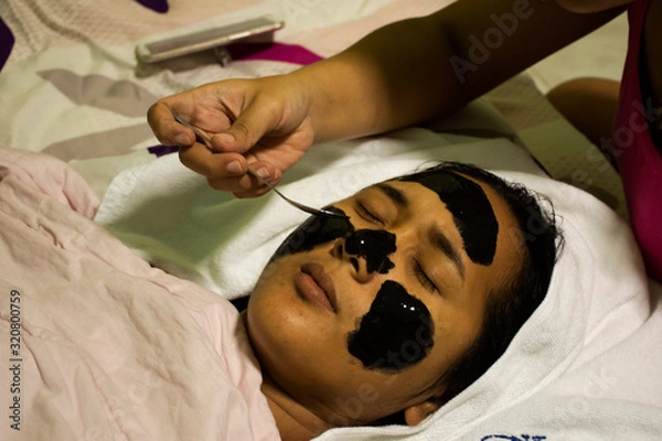 Obraz Thai women sleep for sister making spa and mask and scrub on face on the bed in bedroom at house on November 213, 2018 in Nonthaburi, Thailand