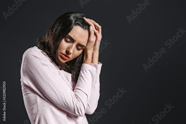 Fototapeta Depressed young woman on dark background