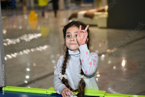 Fototapeta beautiful little girl plays children's games in a children’s play area