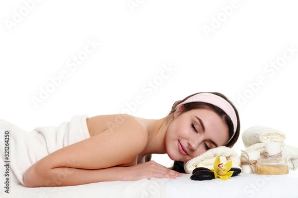 Fototapeta Young beautiful woman relaxing with lotus flower at spa isolated on white background, professional beauty makeup