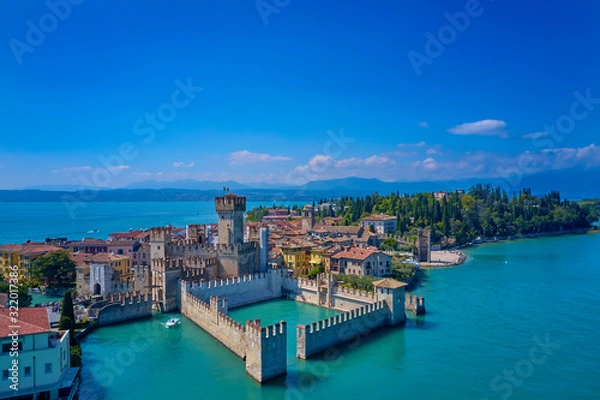 Fototapeta Unique view. Aerial photography, the city of Sirmione on Lake Garda north of Italy. In the background is the Alps. Resort place. Aerial view. Sirmione Castle,