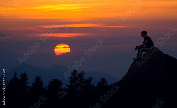 Fototapeta Man silhouette on the sunset background