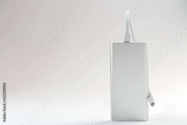 Fototapeta Powerbank for charging mobile devices with cable, on a white background.