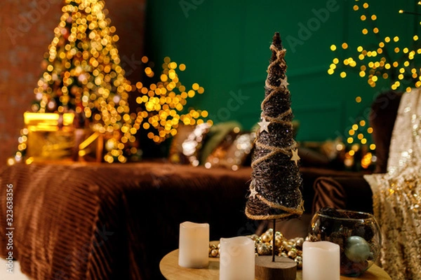 Fototapeta Toy decorative Christmas tree on a table with candles