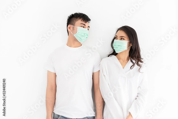 Fototapeta couple asian people wear surgical mask on white background, they want to pollution protection and virus protection, healthcare and infection control