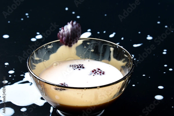 Fototapeta Homemade yogurt with berries. Splash from falling berries