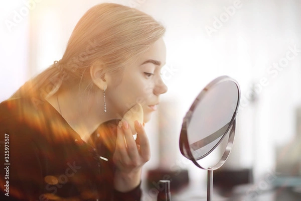 Obraz makeup girl at home by the mirror, young blonde adult model, face cosmetics concept