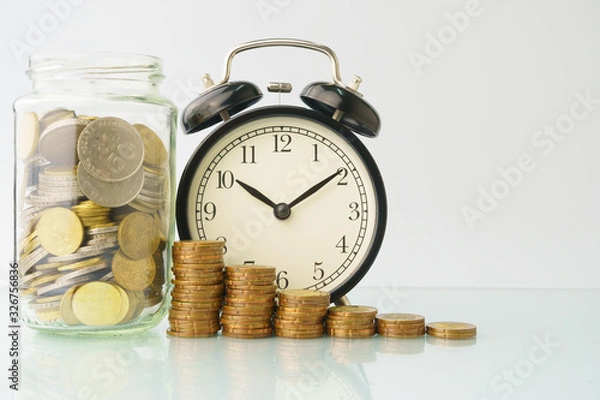 Fototapeta high key. business and finance management conceptual images. stacked money with clock, home replica, bottle of coins isolated against white background with reflection. copy space