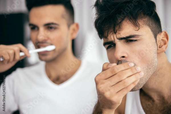 Fototapeta Two young men brushing teeth in the bathroom