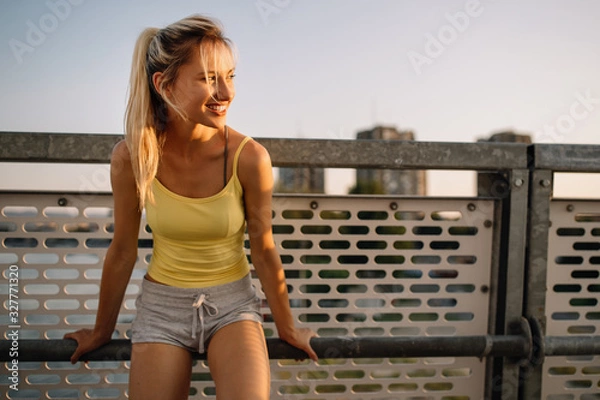 Fototapeta Portrait of a cheerful young sports woman outdoor