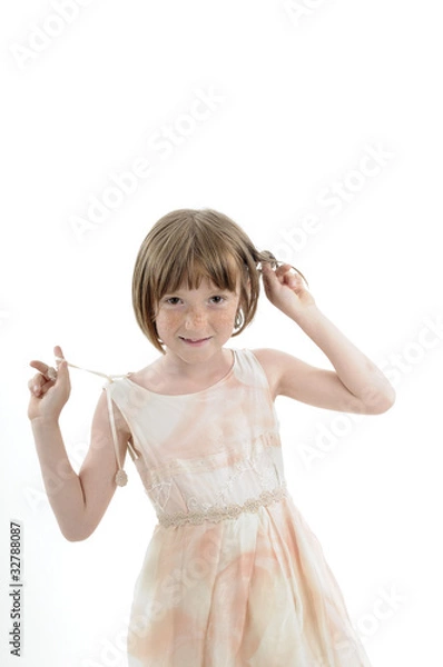 Fototapeta joyful child playing with hair in studio