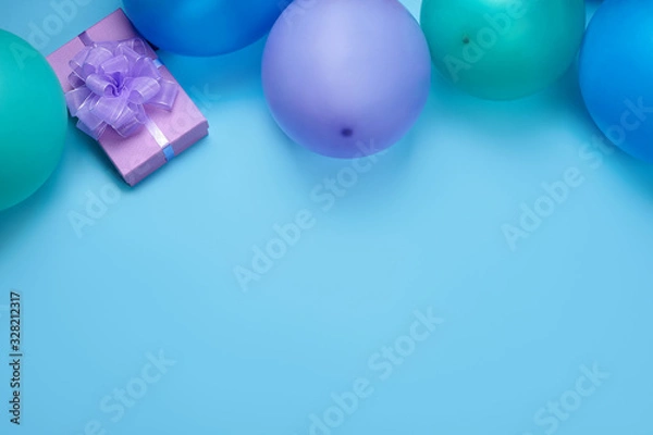 Fototapeta Colorful balloons and gifts on blue background with copy space. 