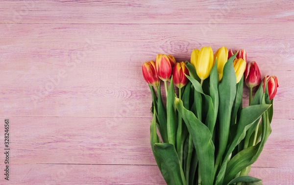 Fototapeta  Bouquet of yellow, red and pink tulips on a pink wooden background copy space.