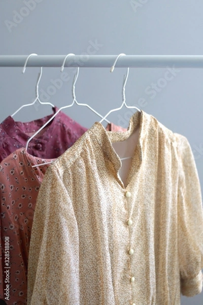 Fototapeta Colorful vintage floral dresses on a clothing rack. Selective focus.