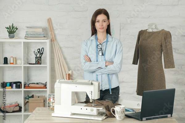 Fototapeta Portrait of young entrepreneur woman in her fashion studio, slow fashion, tailor craft, small business concept	