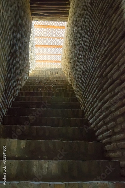 Fototapeta Detail of Ark Fortress architecture: narrow corridor, stone steps and walls. Bukhara, Uzbekistan, Central Asia.