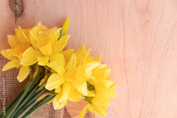 Fototapeta Yellow daffodils on a wooden background. Bouquet of spring flowers. Warm weather.