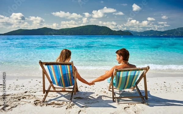 Fototapeta Couple in loungers on a beach at Thailand