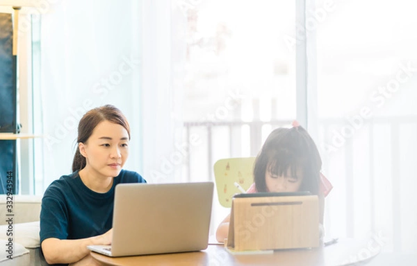 Fototapeta Covid-19 Coronavirus and Learning from home, Home school kid concept.Little asian girl study with online learning and asian mother work from home with laptop.Quarantine and Social distancing concept.