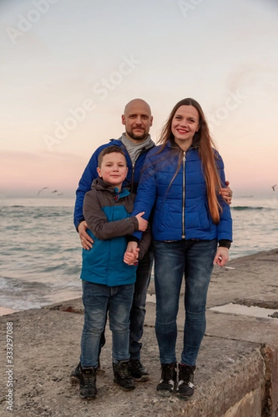 Fototapeta family walk on the sea coast in spring