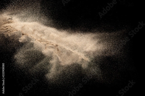 Fototapeta Brown colored sand splash.Dry river sand explosion isolated on black background. Abstract sand cloud.