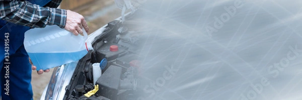 Fototapeta Hands of mechanic pouring windshield washer fluid in a car; panoramic banner