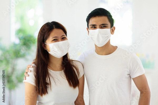 Fototapeta Young Asian couple in face mask in virus outbreak