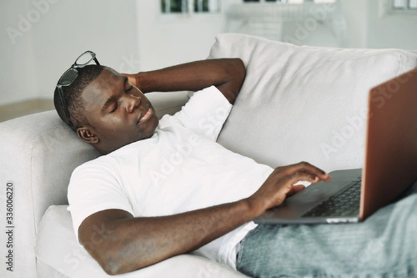 Obraz man relaxing on sofa with laptop