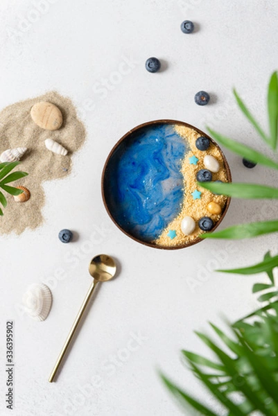 Fototapeta Summer dessert. Smoothie bowl with blue spirulina topped like a beach with sea and sand. Detox, superfoods, dieting, healthy nutrition. Top view