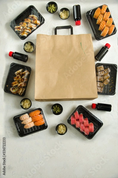 Fototapeta set of sushi rolls in a plastic box, delivered home ready to eat fast healthy food, isolated on white top view. Place for text